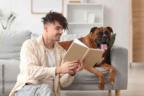 Young man with Boxer dog re...