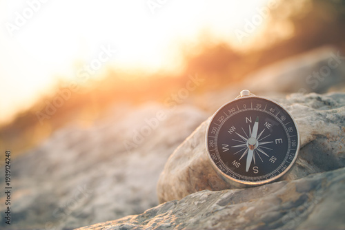 Foto The compass of travel points towards the sun setting in the warm sunlight