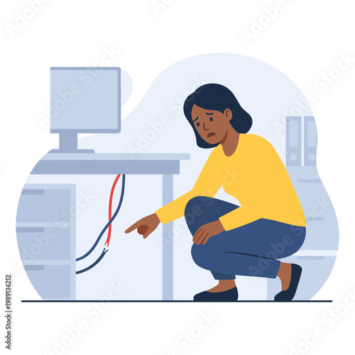 A woman crouches in an office pointing at wires under a desk