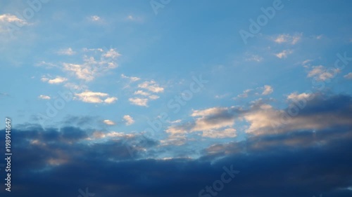 Clouds drift slowly across the evening sky with shifting colors as the sun sets. The light changes and creates a different look throughout the frames.