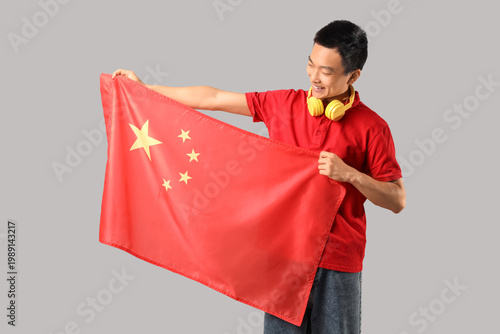 Young Asian man with headph...