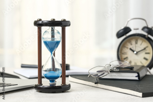 Hourglass with laptop, note...
