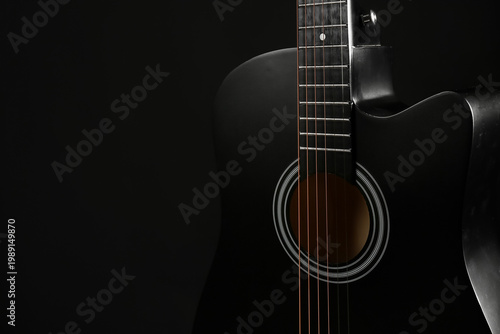 Modern black guitar on dark...