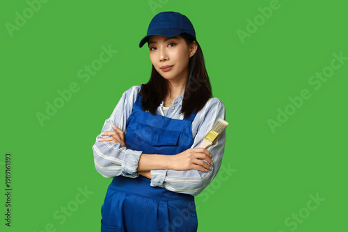Female Asian painter with brush on green background