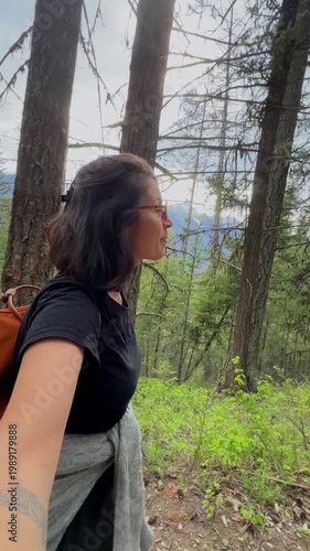 Woman vlogging her hiking adventure in a forest
