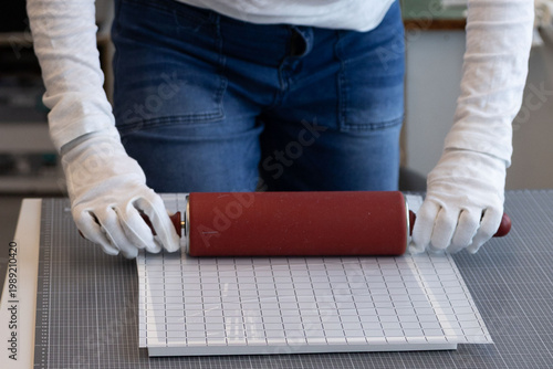Fotografía Close-up of hands using a silicone rolling pin to smooth a printed image onto a surface