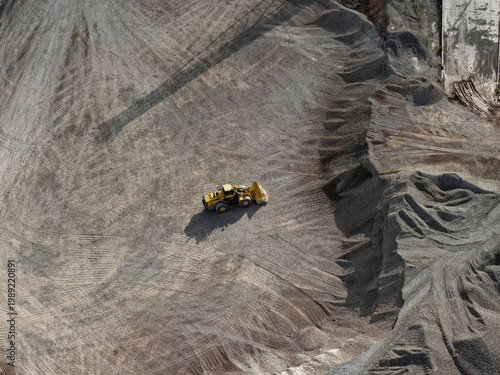 Foto Aerial view of heavy machinery such as a front loader in the process of stockpil