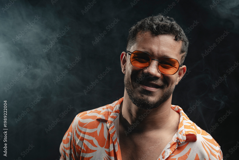 Obraz premium Man in orange sunglasses smiling with smoke