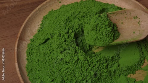 Matcha green tea powder mixing with a spoon