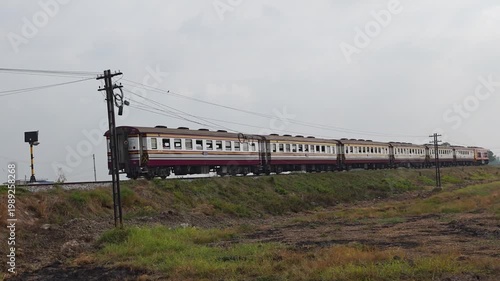 train in the countryside. Locomotive Express Train traveling on a railway pass through g paddy fields in the countryside at prachinburi, Thailand.
