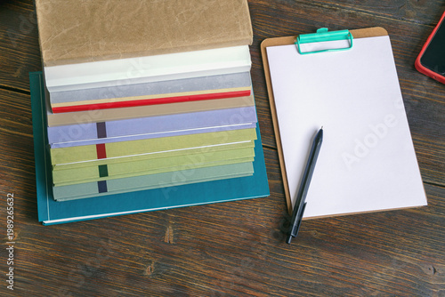 Workspace with stack of books and clipboard. Copy space