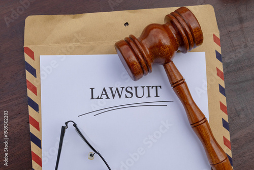 Lawsuit Legal Document with Judge's Gavel and Reading Glasses on Desk