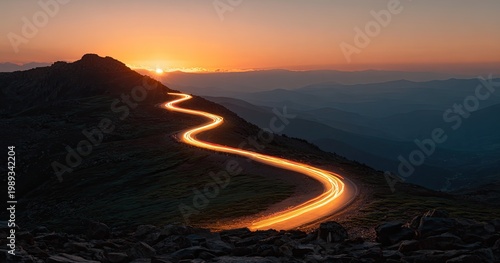 Serpentine Mountain Road Illuminated by Car Headlights at Sunset.