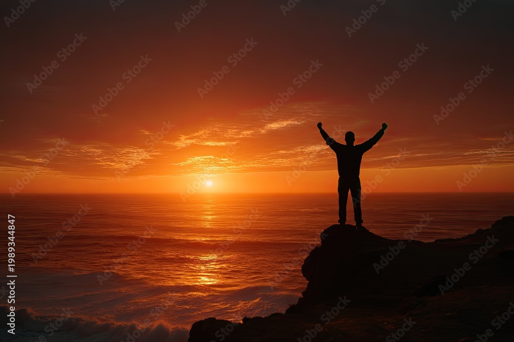 Fototapeta premium Silhouette of a person celebrating on a cliff edge at sunset
