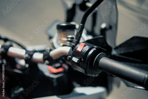Bild auf Leinwand Motorcycle throttle and control detail with red switch, brake lever and reservoir showing modern mechanical design