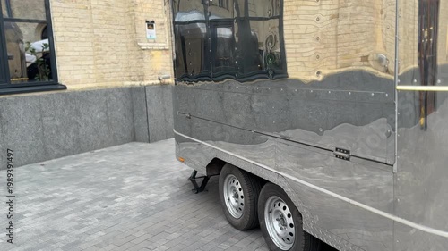 Utility trailer parked in urban courtyard, transportation and logistics concept, cargo vehicle, outdoor scene, minimal industrial environment with copy space