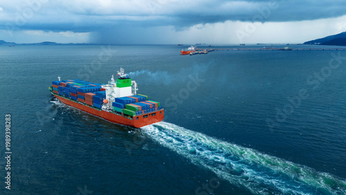 Obraz na płótnie large cargo container ship leaving a white wake as it sails towards a dramatic dark storm and heavy rain over the ocean