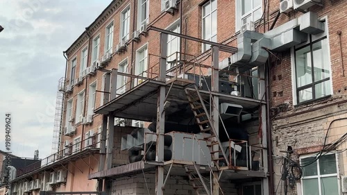 Old building facade with metal staircase, urban architecture concept, industrial exterior, city environment, vintage structure, outdoor scene with copy space