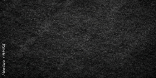 A dark grunge backdrop featuring a macro view of rough black fabric and textured leather material creates a blank gray surface design for a textile wallpaper background