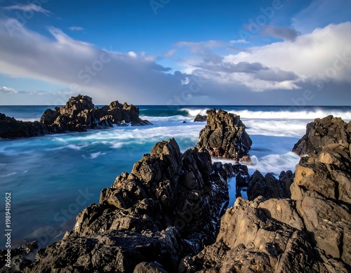 Coastal Volcanic Rock Formations With Long Exposure Silky Blue Water Waves Under Cloudy