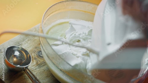 Using a mixer to blend whipped cream into ice cream custard