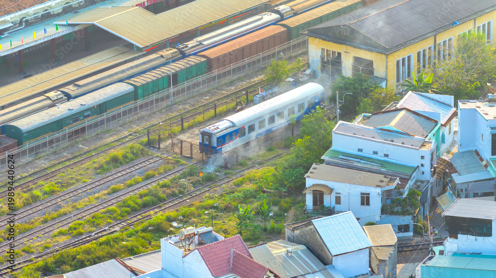 Fototapeta premium An aerial view of Nha Trang Railway Station, Vietnam showcasing a busy transport hub in the heart of the city. Trains line multiple tracks while the station building with its classic architecture