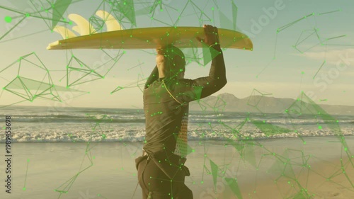 Surfer shifting stepping to waves on sand carrying yellow board to surf while green overlay growing