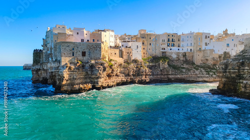 White houses on a rocky cliff in Polignano a Mare in Puglia, seen from Lama Monachile beach