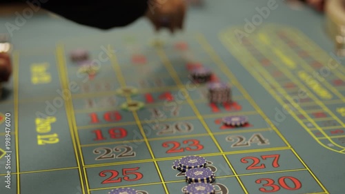 Hands placing bets on roulette table in casino, close up
