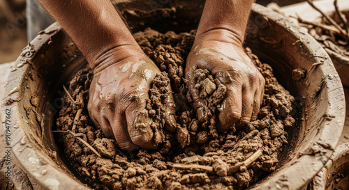 Hands Mixing Mud and Straw for Adobe Construction.