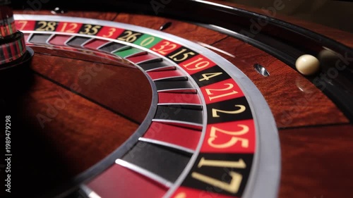 Hand spinning roulette wheel with ball in casino, close up