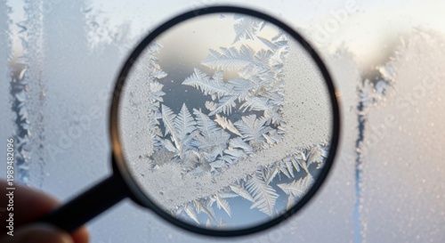 Magnifying Glass Reveals Intricate Ice Crystals on Frozen Window