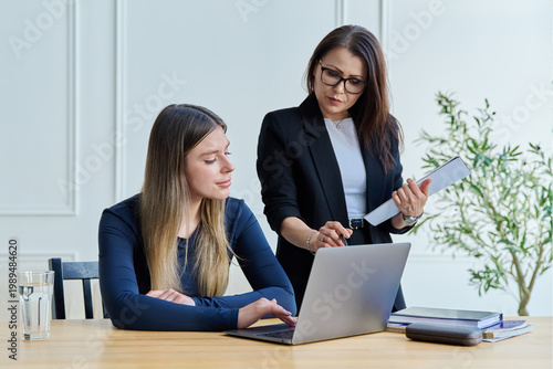 Confident female mentor teacher advising teaching young woman university student