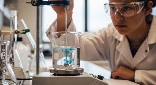 Student mixes solutions with magnetic stirrer in laboratory