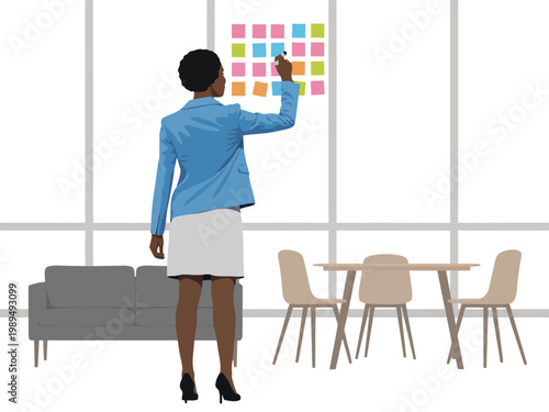 Businesswoman stands in a modern office while placing sticky notes onto a large glass window wall.