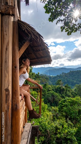 A woman enjoys the panoramic view from a wooden cabin balcony nestled amongst lush green treetops on a bright sunny day