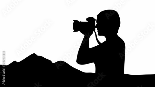 Silhouette of a professional photographer capturing scenic mountain landscapes with a digital camera during a bright sunset against a stark white background