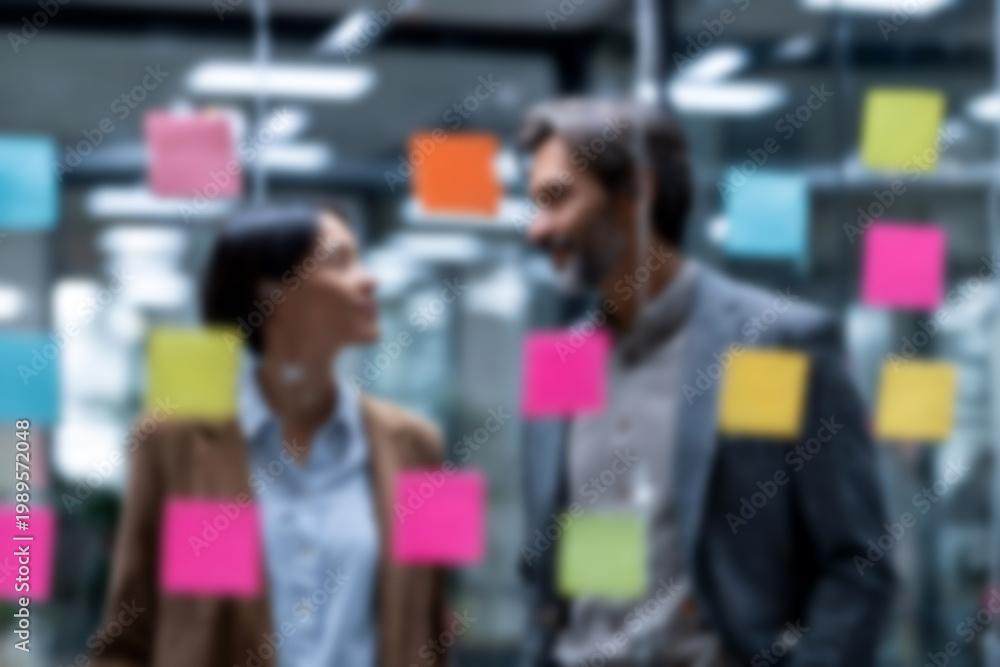 Fototapeta premium Blurred Business colleagues collaborating with colorful sticky notes in modern office