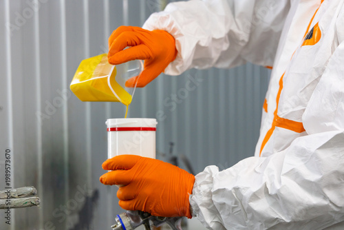 Foto Pouring Yellow Paint into Spray Gun Container Industrial Close Up