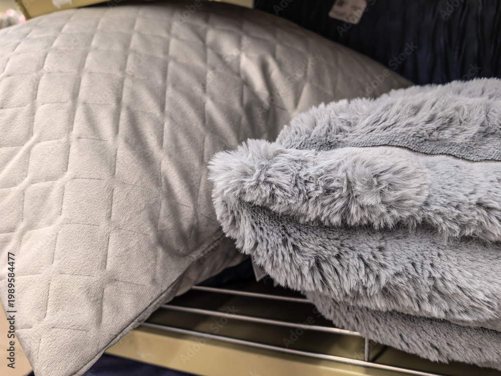 Fototapeta premium Soft gray pillow and fluffy blanket on store shelf