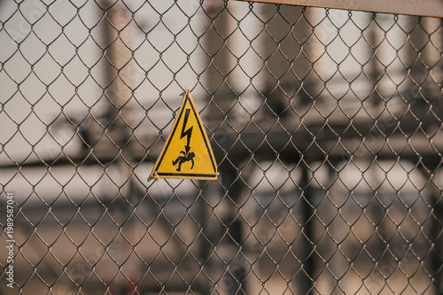 Принти на полотні High voltage warning sign attached to metal fence in front of electrical substation