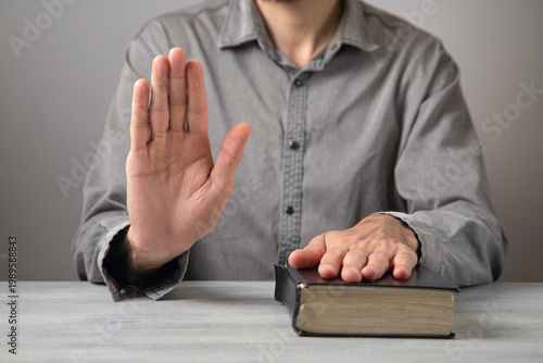Tableau sur toile Man taking oath with hand on book.