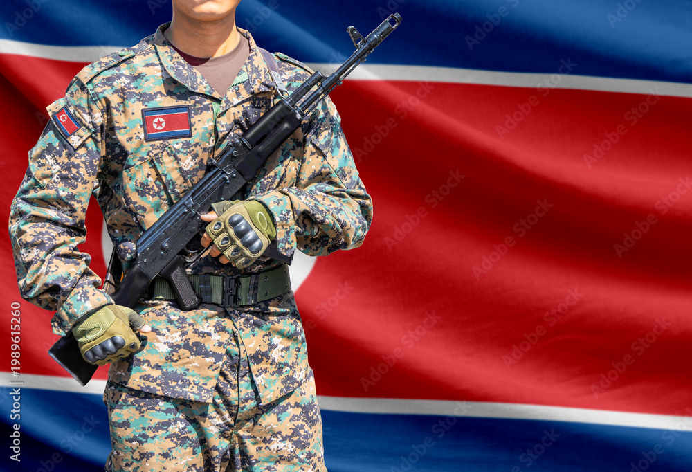 Naklejka premium North Korea flag with soldier holding assault rifle