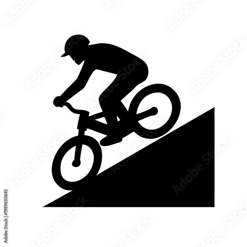Silhouette of a mountain biker riding downhill on a steep slope