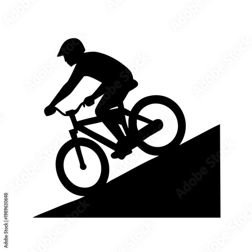 Silhouette of a mountain biker riding downhill on a steep slope