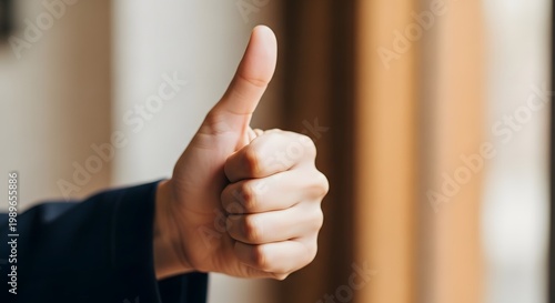 Close-up shot of a hand giving a thumbs-up gesture, signifying approval or agreement in a positive manner