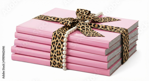 Stack of pink books, elegantly tied with leopard print ribbon and delicate pearls, delightful gift