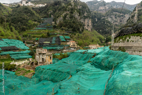 Sfusato lemon grove covered by protective netting in a mountainous valley on a heavily overcast day, Amalfi, Amalfi Coast, Southern Italy	