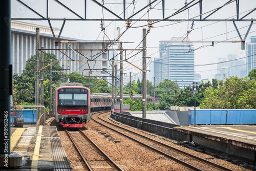 Canvas Print A local commuter train, in Jakarta, Indonesia, arriving at the station