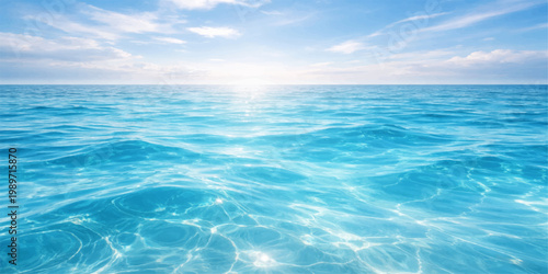 A serene summer landscape of the clear blue sea water under a bright sky with calm waves and soft clouds reflecting the sun at the ocean horizon